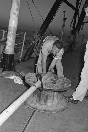 [Men with core barrel on deck of R/V Spencer F. Baird]