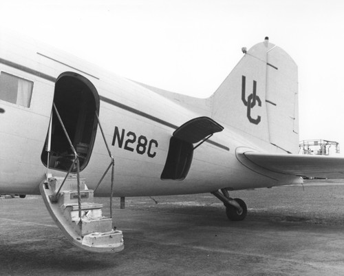 In 1962 Applied Oceanography Group (AOG) at Scripps Institution of Oceanography leased this DC-3 airplane. This photo shows the entry steps and cargo side door of the aircraft. Later the plane would be given to them for continued research; AOG then mounted an infrared radiometer to measure heat flow from the ocean in the plane. With the airplane it was possible to survey 10,000 square miles of sea surface in 24 hours. Circa 1965
