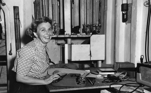 Helen Hill Raitt, the first woman to take part in an extended American oceanographic expedition called the Capricorn Expedition (1952-1953); she is doing clerical work at a desk during this expedition on the R/V Spencer F. Baird (ship). Capricorn Expedition was the first Scripps Institution of Oceanography expedition to use scuba divers to explore the Pacific. Research ships Horizon (ship) and Spencer F. Baird (ship) mapped seamounts and guyots and other features of the Pacific seafloor. Scientists studied the 35,400 foot deep Tonga Trench, the second deepest place in the ocean, and measured heat flow on the East Pacific Rise. Circa 1953