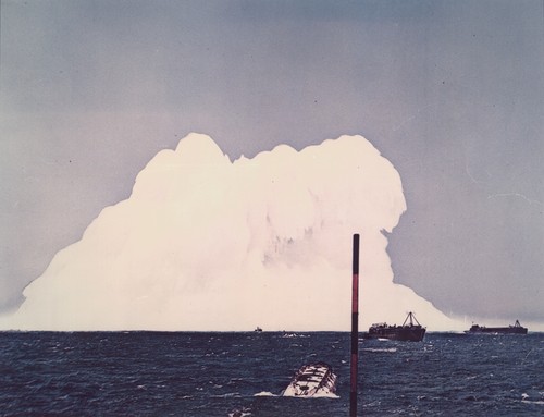 Operation Wigwam Underwater Atomic Explosion. The photograph shows the explosion plume from a 20-kiloton atomic device detonated one-half mile beneath the ocean surface 700 miles southwest of San Diego in May 1955. The device was suspended from a raft fabricated from empty oil drums, and which was towed upwind behind a navy fleet tug by a seven mile cable buoyed by floats at 200-ft intervals. More than 150 instruments for recording various phenomena were deployed along the cable, including two balloons at 1500 feet above the surface and two scale model submarines 300 feet beneath the surface. SIO participation in this exercise, under the direction of Gifford Ewing, Associate Research Professor, included the M/V HORIZON, which tracked surface radiation and temperature, and to drop the original Van Dorn water samplers that were to be picked up by helicopters for early-time energy analysis. Both aircraft and helicopters operated from the light carrier WRIGHT (CVL49). The plume height is about 1600 feet and diameter one mile. I was aboard the lead aircraft flying directly over the plume at an altitude of four thousand feet when this photo was taken