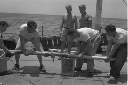 [Men with core barrel on deck of R/V Spencer F. Baird]