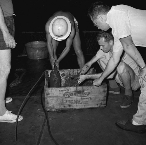 [Oceanographers examining contents of Peterson grab sampler]