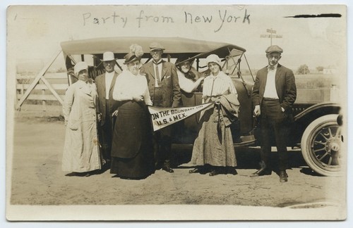 Tourists near automobile with "On the boundary line" pennant