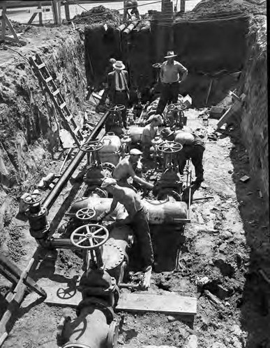 Workmen installing new 12" service for fire protection at MGM studios