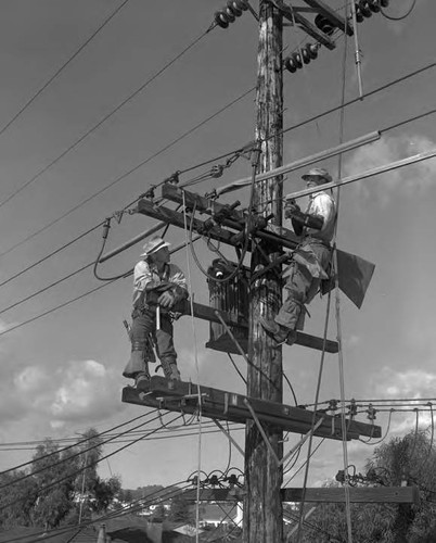 Linemen at work with safety equipment in place