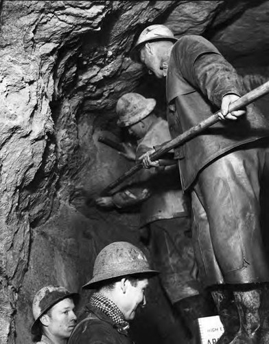 Miners placing dynamite in face of tunnel