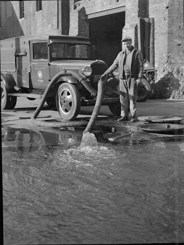 Joel A. Johnson shows how special pump cars quickly empty flooded manholes