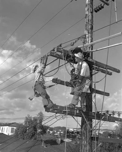 Linemen at work with safety equipment in place