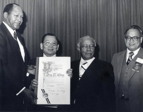 Poy Wong receiving a certificate from Mayor Tom Bradley and Councilmember Gilbert Lindsay with Irvin Lai on the right