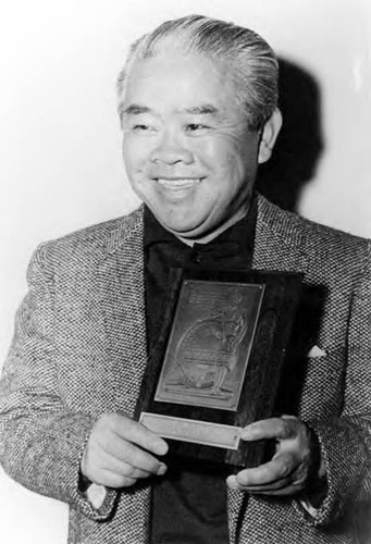 Photograph of James Wong Howe holding an award