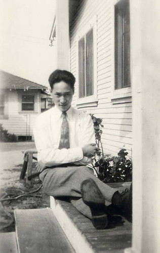 Chinese American man seated on the steps of a front porch