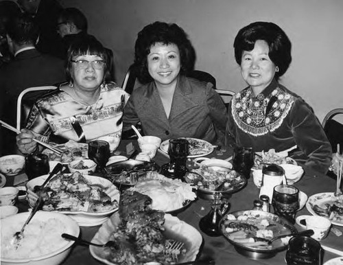 Photo of Lily Chan, left, and Mrs. Ann Lew, far right, eating dinner