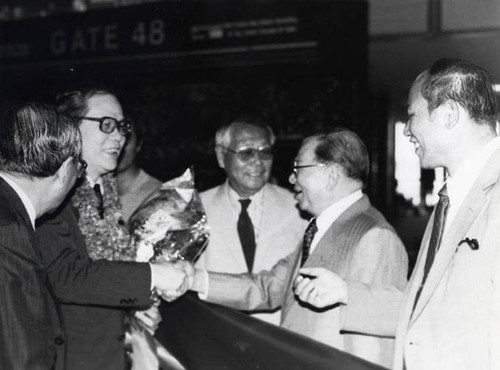 Welcoming China Overseas Affairs Direction from Taiwan, Republic of China, Poy Wong shaking hands with director who is wearing a lei, and holding flowers