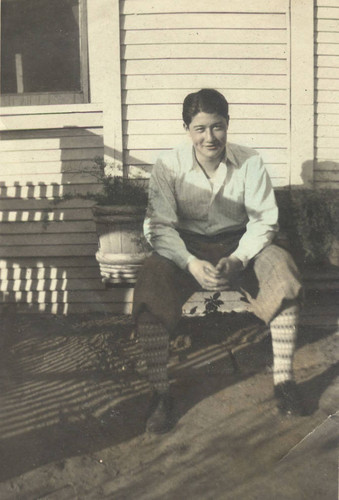 Jake sitting on a ledge outside of a house