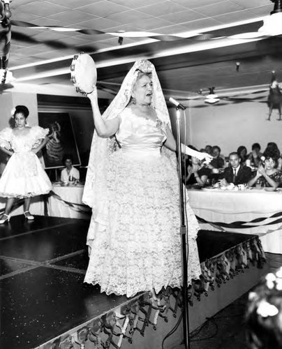 Consuelo Bonzo onstage holding a tamborine