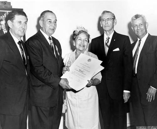 Consuelo Bonzo recieving a certificate from 4 men, including Mario Valadez