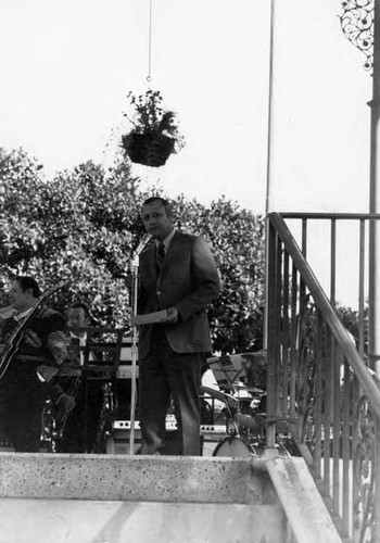 Man standing in Kiosko talking into a microphone