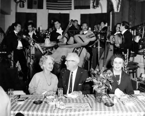 A man and two women at a luncheon