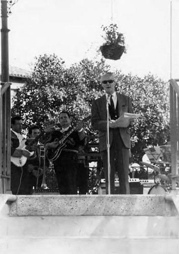 Man talking into a microphone in the kiosko