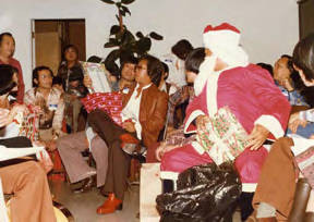"Kellogg Chan's Christmas," Gerald Jann dressed as Santa Clause distributing gifts to party guests