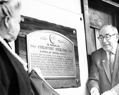 Man and woman next to the Christine Sterling plaque