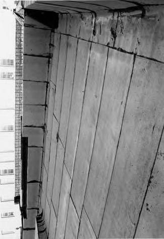 One of eight photographs of puestos at the Macy end of Olvera Street. The photographs include views of the roofs and detail shots of the brick/adobe walls