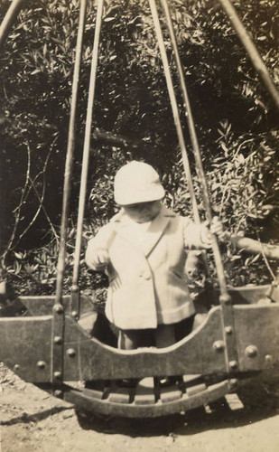 Rodney Low standing on a wooden swing