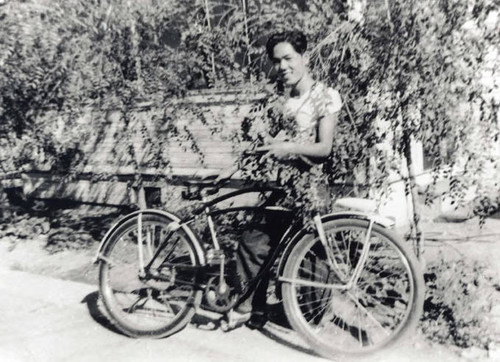 Man standing behind his bicycle