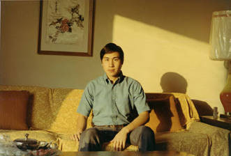 Henry Quan seated on a couch