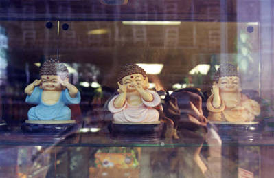 Three Buddha statues in a store window in San Gabriel Square