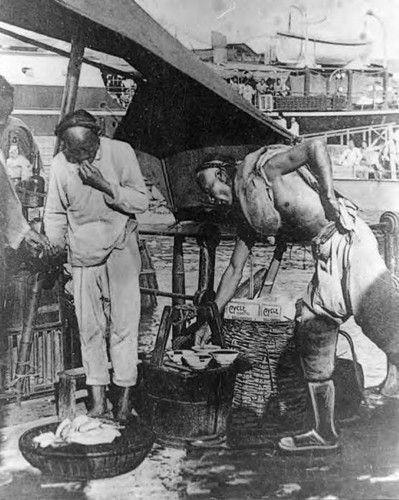 Man bending over to get a bowl on a boat