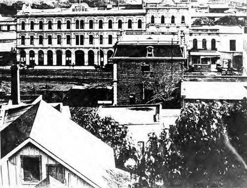 The Pico House from Fort Moore Hill. Note the streetcar tracks running down the middle of Main Street. Also, to the left, one sees a fragment of the Plaza, and the adobe structures which actually stand south of the Lugo Adobe on what is now Los Angeles Street, then Calle de los Negros