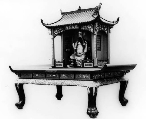 Photograph of "Quan Ti" Temple Altar with Quan Dai deity. Altar was brought over from China by "Tony" Quan, to set up a one-room temple near his business on Spring Street