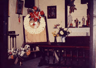 Altar and wreath of white flowers in Avila Adobe