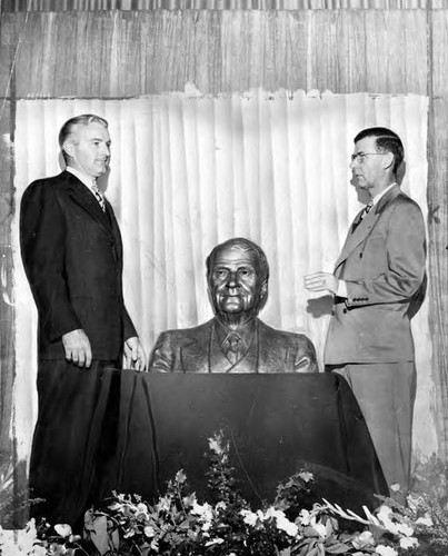 Otis Chandler and Ed Ainsworth with bust of Harry Chandler