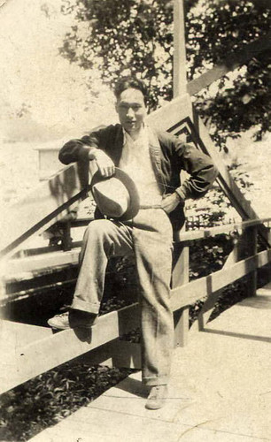 Photo of a Chinese American man posed next to a fence