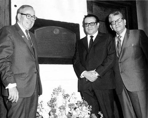 Three men standing by the Christine Sterling plaque