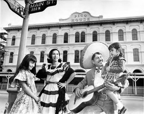 Man, woman and two girls in front of the Pico House during restoration