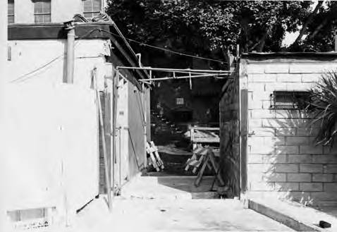 One of eight photographs of puestos at the Macy end of Olvera Street. The photographs include views of the roofs and detail shots of the brick/adobe walls