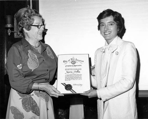 Maria Pollia is being handed a Certificate of Appreciation by Pandora Hollister at the premier of "Pueblo of Promise" film