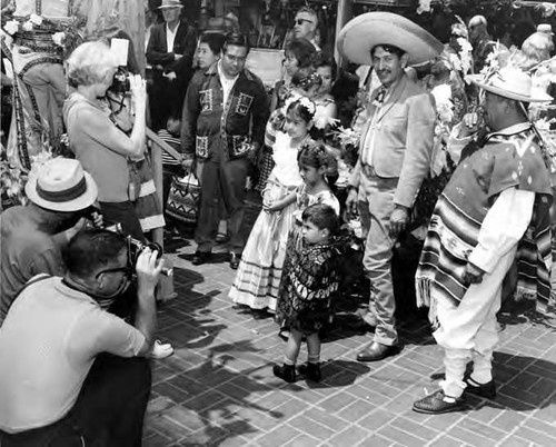 Group taking pictures of men and children in Mexican costumes