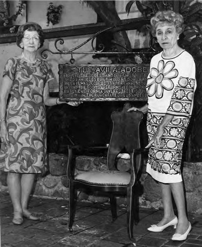 Two ladies by Avila sign and chair