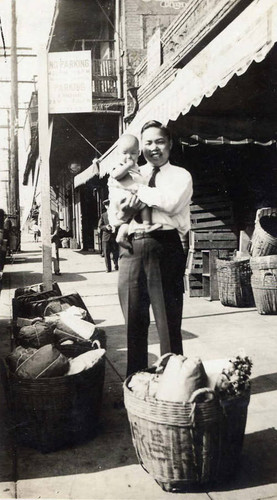 Mr. Dick Tom and son in front of Wing Chong Long Store, Marchessault Street