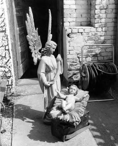 Angel looking down on the baby in the crib, part of nativity scene