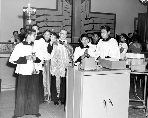 Priest and altar boys blessing the interior of the Simpson building