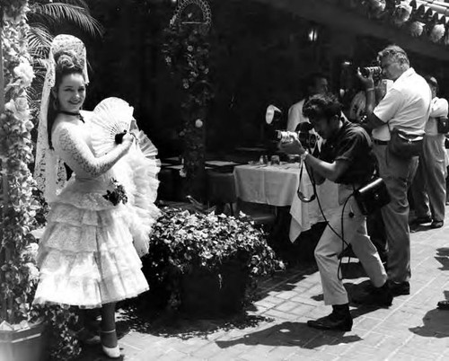 Men taking pictures of woman in Spanish costume