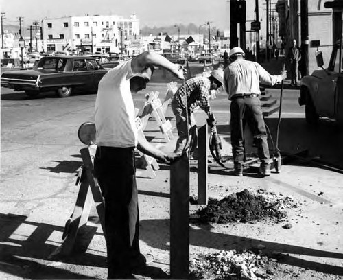 Workers putting in posts while closing Sunset Boulevard