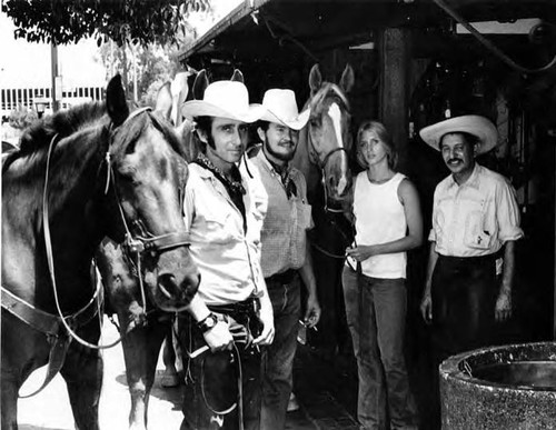 Three men, one woman with horses at the Macy Street/Alameda Street parking lot