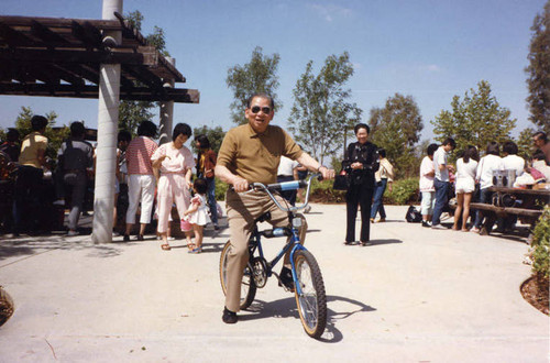 Poy Wong riding a bike at the Wong Family Association picnic