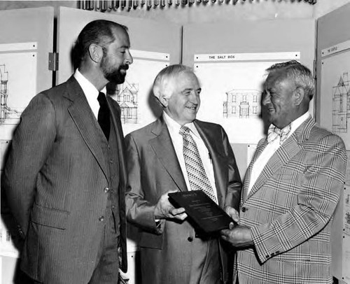 Mario Valadez acceptin an award for Christine Sterling, with William K. McClelland and Edward Gazelle standing by